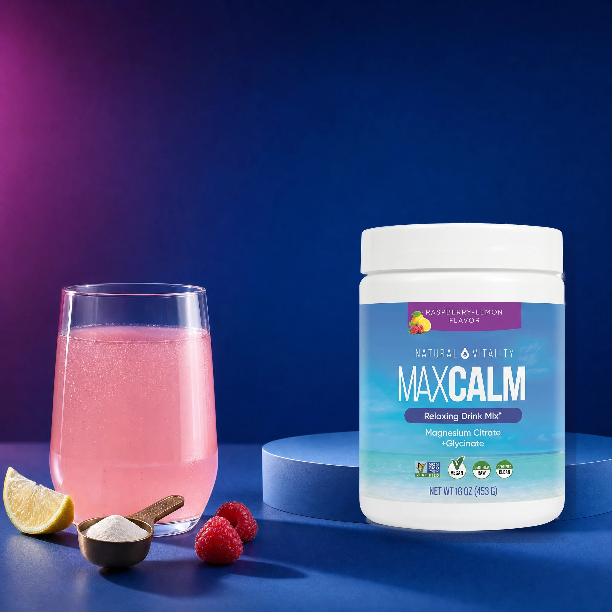 MAXCALM junto a una bebida rosada, cuchara medidora, frambuesas y limón
